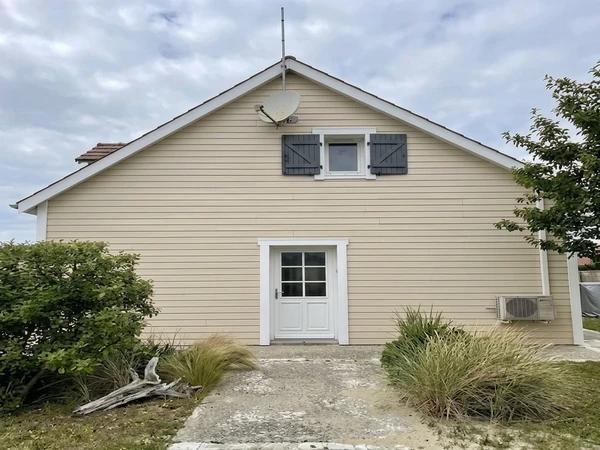 Cape Cod exterior in Behr Almond Wisp cream with charcoal shutters, AI color preview